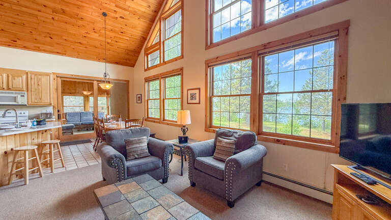 Unwind in your cozy living room with soaring ceilings and stunning lake views. Natural light floods the space, perfect for relaxing after a day of adventure.