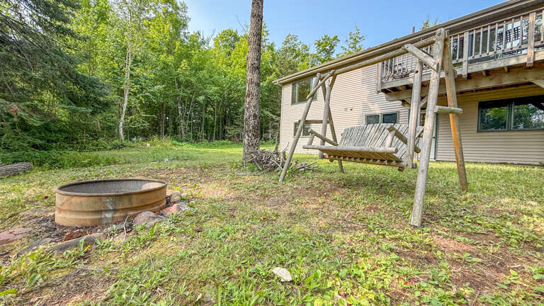 Nestled in lush woodland, the property features a swing for two and a fire pit, perfect for evenings beneath the trees.