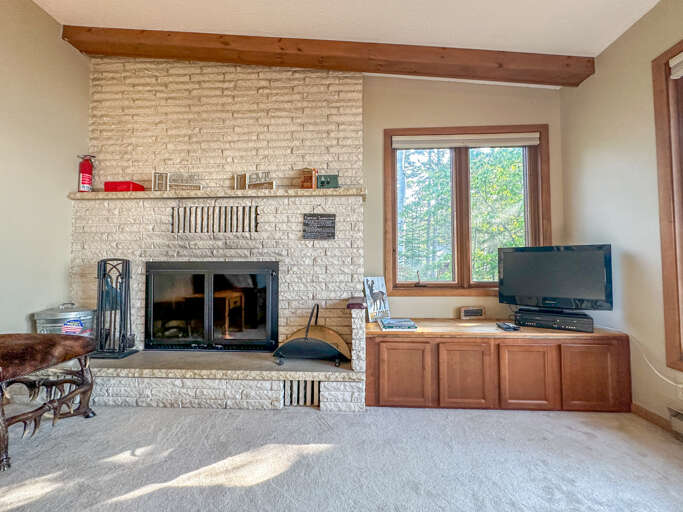 The living room features a wood-burning fireplace and a TV with a video collection. The living room features a wood-burning fireplace and a TV with a video collection.