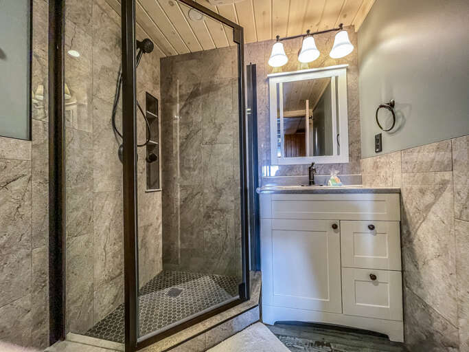 The lower level bathroom has a glass surround shower.