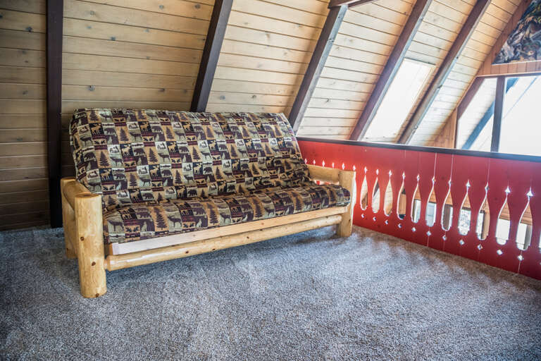 Above the living room is an open loft area with a futon that serves as an additional sleeping area. Above the living room is an open loft area with a futon that serves as an additional sleeping area.