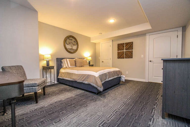 The bedroom is located on the main level of the apartment and features a queen bed.