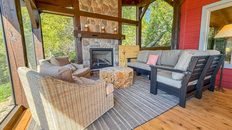 Sink into plush seating and let the warmth of your fireplace embrace you while greenery frames your peaceful escape through floor-to-ceiling windows.