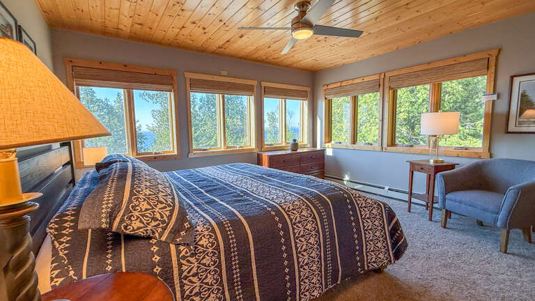 Wake up to breathtaking water views framed by floor-to-ceiling windows, where the natural wood ceiling and cozy furnishings invite your most restful mornings.
