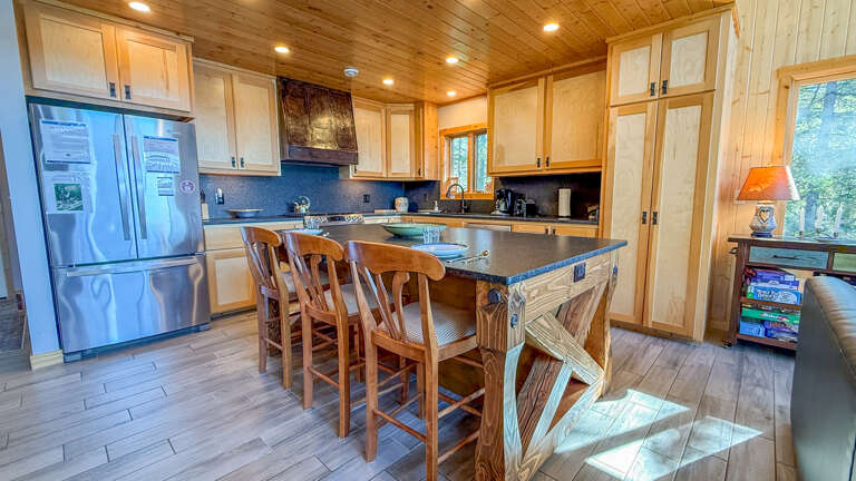 Your fully equipped kitchen invites you to gather around the spacious island, with warm wood tones and plenty of counter space for preparing meals together during your stay.