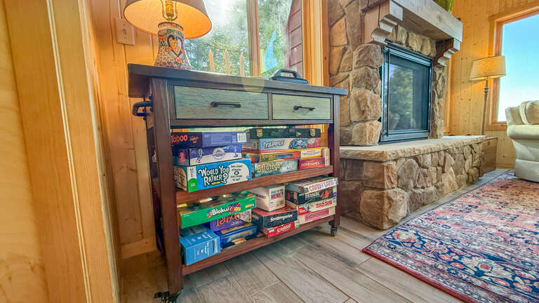Gather around for game night in your cozy retreat, where a well-stocked cart of classics awaits your competitive spirit by the warm stone fireplace.