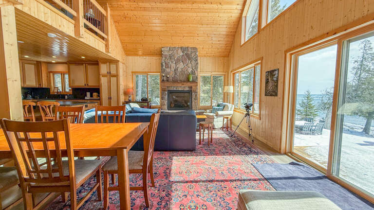 Gather around the stone fireplace while your meals cook in the full kitchen, with lake views through expansive windows creating the perfect lakehouse retreat.