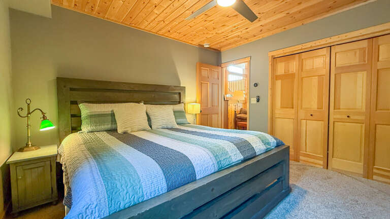 Sink into this cozy bedroom with its plush bedding and warm wood accents, offering you a peaceful retreat after your mountain adventures.