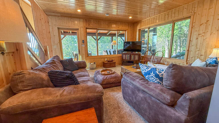 Sink into plush sofas surrounded by warm wood walls and enjoy views of lush greenery through oversized windowsâyour perfect retreat for relaxing after a day of adventure.