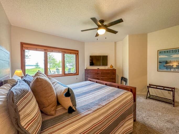 Guests bedroom one offers a queen bed and lake facing windows.