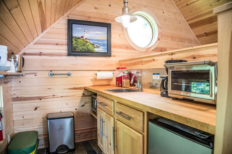 The kitchen offers a small fridge, toaster oven and a microwave.