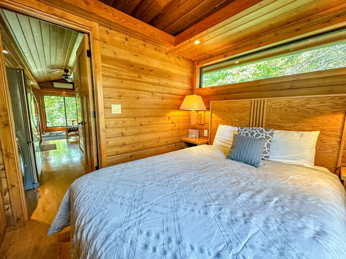 The bedroom is located on the opposite end of the home from the living room with the kitchen and bathroom in between.