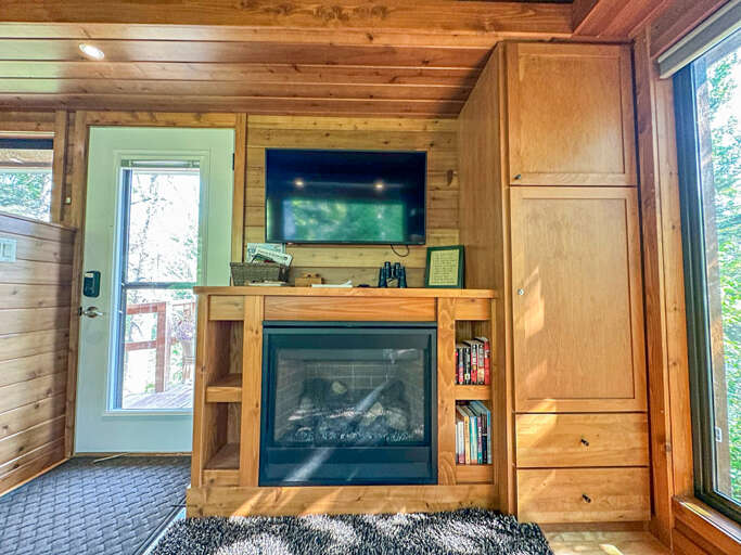 The home has a cozy living room a SmartTV and gas fireplace.