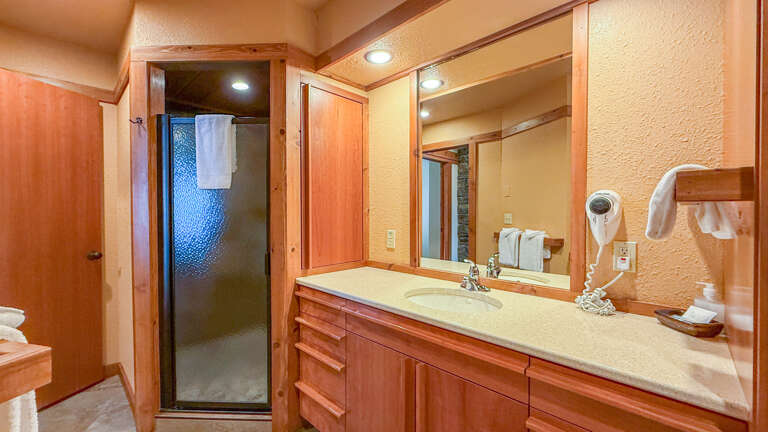 The bathroom has a large vanity and walk in shower.