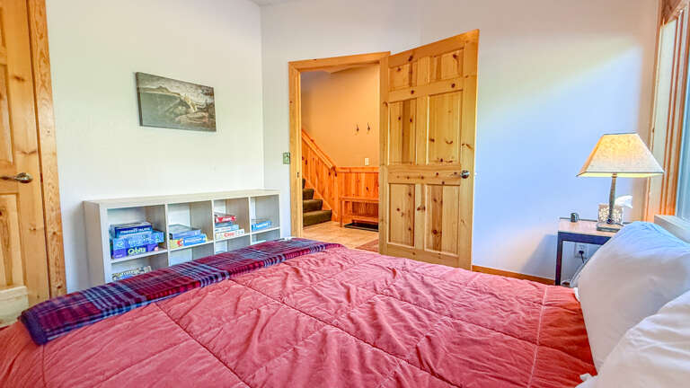 Main level bedroom looking out a the entryway and staircase to the upper level.
