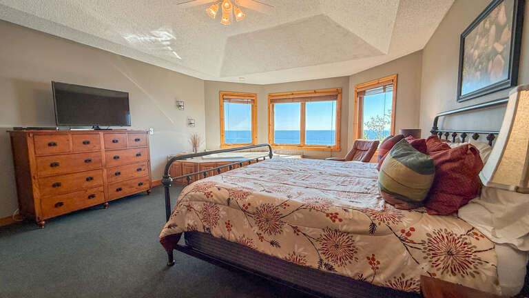 The spacious primary bedroom on the upper level has incredible Lake Superior views.