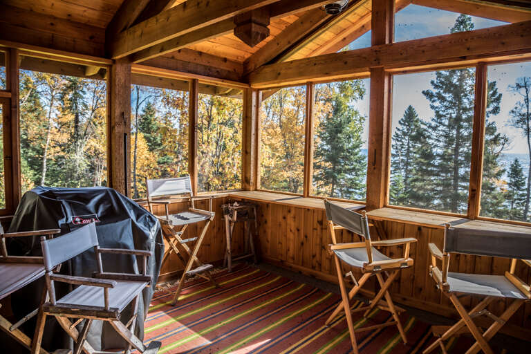 Gather inside the screened-in porch area on summer nights to enjoy the beautiful outdoors and the sounds of the waves against the Lake Superior shoreline..