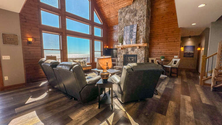 The living room features a two-story stone surround fireplace.