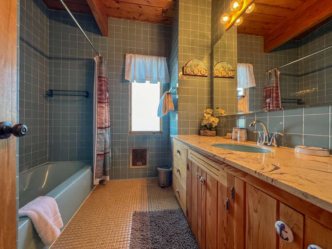 The upper level bathroom features vanity with a large mirror.