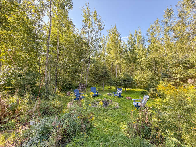 The yard space is dominated by a large fire pit.