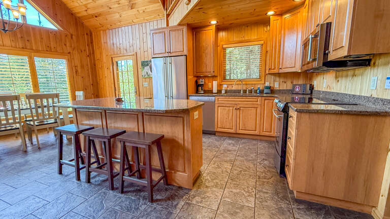 Gather around the island for morning coffee or meal prep in this spacious kitchen. Warm wood tones and granite counters make cooking feel effortless and inviting.