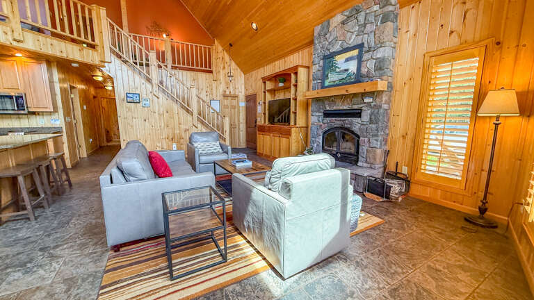 Settle into this inviting living space where vaulted wood ceilings and a striking stone fireplace create a warm mountain retreat for your stay.