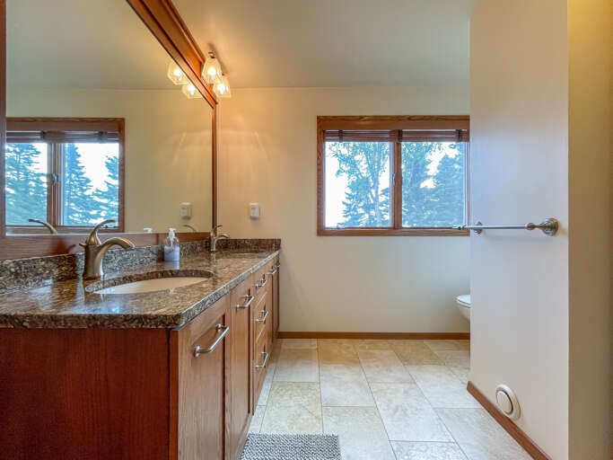 The bathroom attached to Bedroom 1 features a walk in shower, a tub, and a large vanity