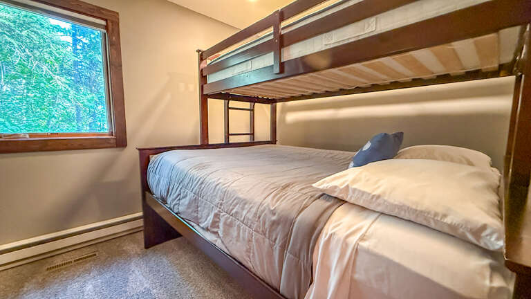 Cozy bunk room with a woodland viewâperfect for the kids or extra guests. Wake up to natural light streaming through the window and fresh forest air.