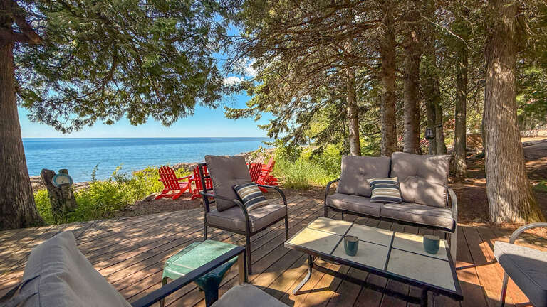 Settle into your private lakefront deck, where plush seating and towering pines frame uninterrupted water views—perfect for morning coffee or sunset gatherings.