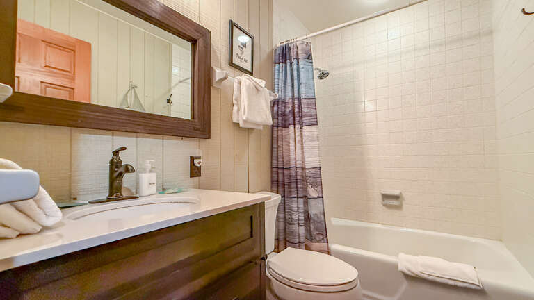 Your private bathroom features crisp white subway tile, a full tub-shower combo, and cozy farmhouse touches that make freshening up feel like a treat.