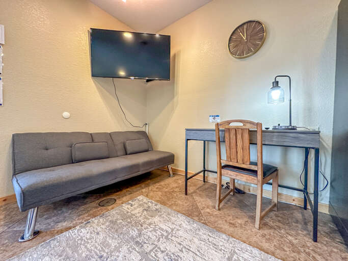 There is another futon, a desk, and a TV in the studio.