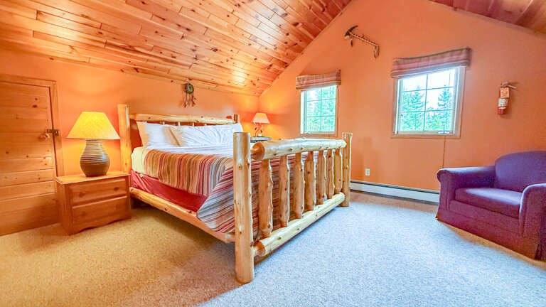 Step into your peaceful retreat with rustic log bed framing, warm wood ceilings, and a cozy reading nook tucked in the corner for quiet moments away from it all.