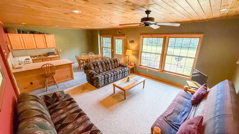 Stretch out and relax in this cozy open-plan space where the living area flows seamlessly into your fully equipped kitchen. Sunlight pours through large windows, inviting you to unwind on plush seating or enjoy meals together at the dining table.