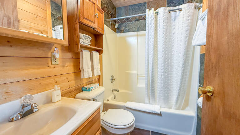Relax in your private bathroom with a tub-shower combo, fluffy towels, and wood-paneled charm. Everything you need for a refreshing start or peaceful wind-down.