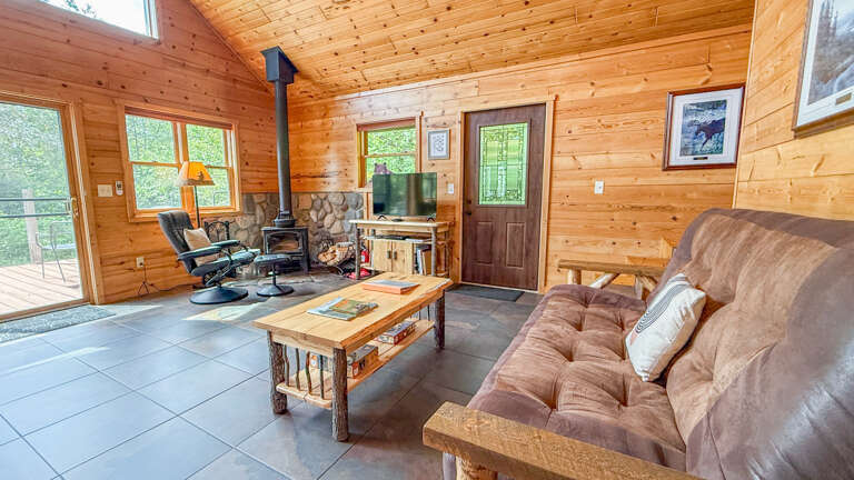 Unwind in your cozy cabin retreat with warm wood walls, a crackling fireplace, and comfortable seatingâperfect for relaxing evenings after exploring nature.