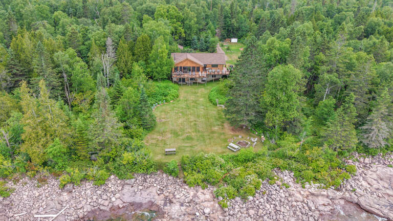 A charming lakefront retreat nestled within lush forest, offering a peaceful escape with waterfront access and expansive grounds perfect for outdoor recreation.