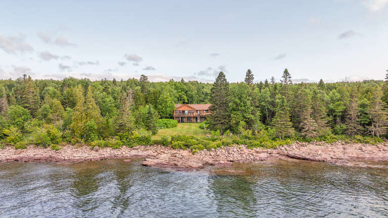 A peaceful waterfront property nestled among dense forest, offering scenic river access and natural surroundings for a serene getaway.