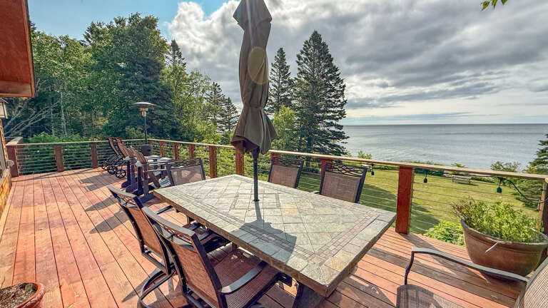 Picture yourself gathering at this spacious deck table, surrounded by lush forest and stunning lake views. The perfect spot to enjoy your morning coffee or evening meals while taking in the peaceful waterfront setting.