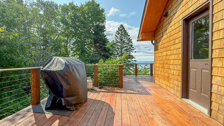 Your private deck stretches toward lush treetops and scenic vistas, perfect for morning coffee or evening grilling on the covered BBQ.