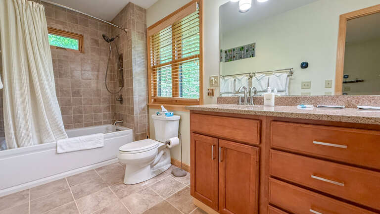 Relax in your spa-inspired bathroom, where natural light streams through wooden blinds onto warm tile floors. The full tub and separate shower offer your choice of unwinding after a day of adventure.