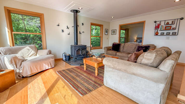 Sink into plush sofas beside a cozy wood-burning stove, where leafy views through large windows bring the forest right to your doorstep.