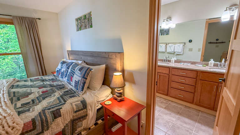 Wake up to the gentle rustle of leaves through your window, then step into your private bathroom with its warm wood vanity and well-appointed fixturesâyour cozy retreat awaits.