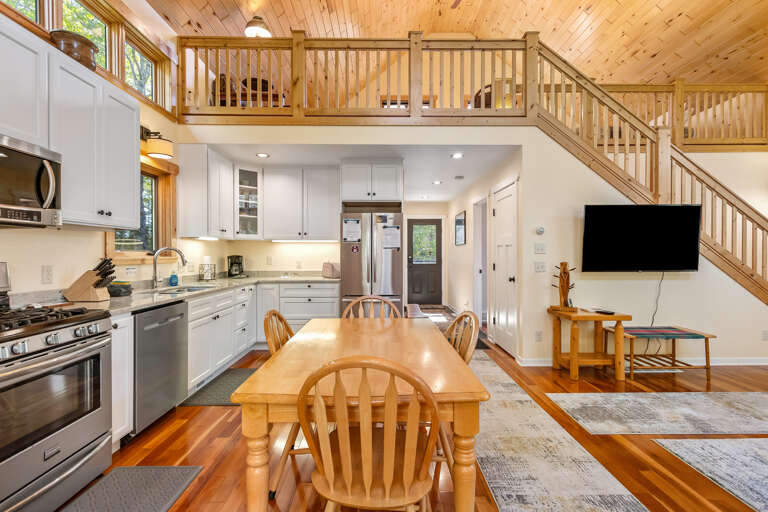 Warm wood tones and open design create a welcoming retreat. Your kitchen flows seamlessly into the dining and living areas, while the loft above adds extra charm and space to unwind.