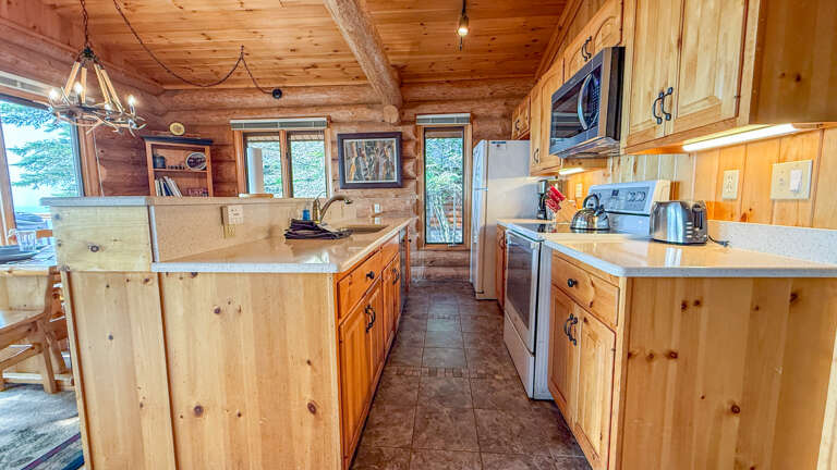 Your fully-equipped kitchen features rustic pine cabinetry, granite counters, and all the modern appliances you need to whip up meals in the heart of this cozy log cabin retreat.