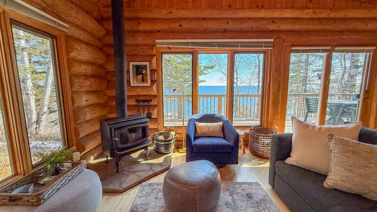 Cozy up in your rustic living room where warm wood surrounds you and stunning lake views stretch beyond the deck.