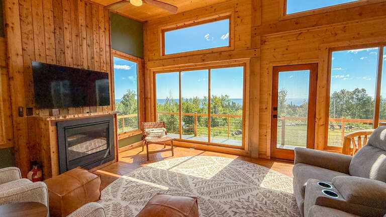 The living room features a TV, gas fireplace, and beautiful Lake Superior views.