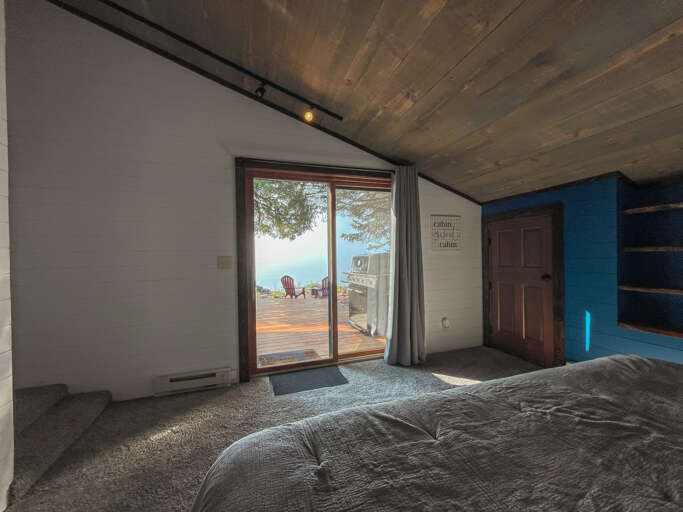 Wake up to stunning water views from your cozy bed. Step through sliding doors onto your private deck where blue skies and peaceful shores await your morning coffee.