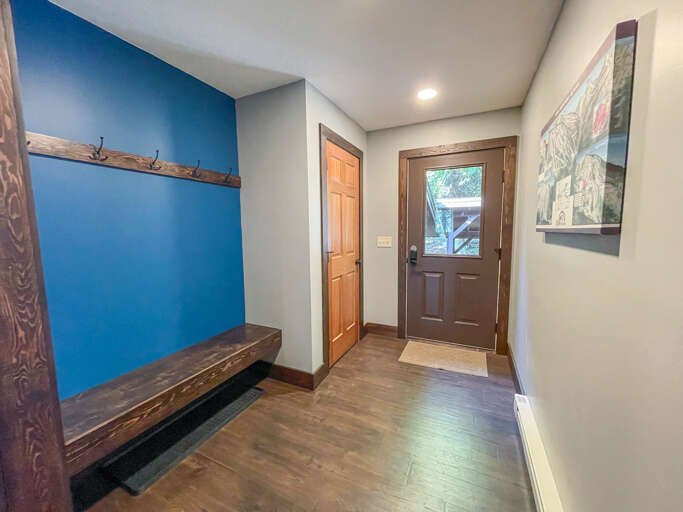 Step inside to a welcoming entryway with rustic wood bench, handy coat hooks, and warm touches that make you feel right at home from the moment you arrive.