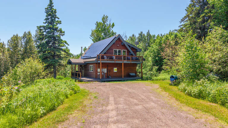 A charming mountain cabin nestled among towering pines and lush greenery, offering a private woodland retreat with rustic appeal and scenic natural surroundings.