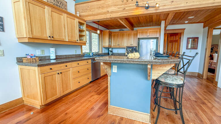 Your spacious kitchen welcomes you with warm wood cabinets, granite counters, and a breakfast bar where you can start each morning.